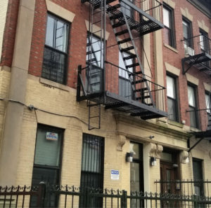 Front of brick building with fire escape